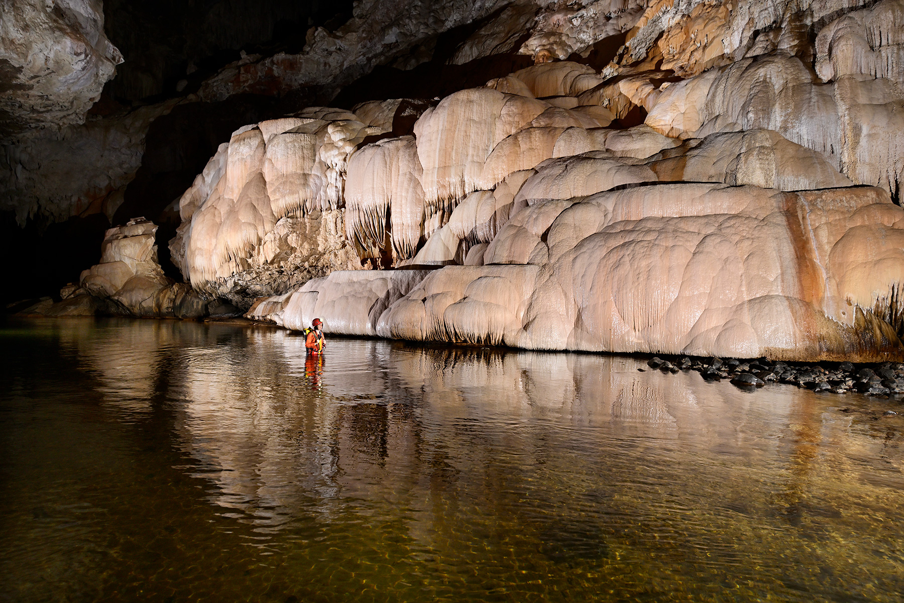 Lapa Terra Ronca (Terra Ronca, Goias) - Spéléo progressant dans la rivière bordée de grandes coulées de calcite